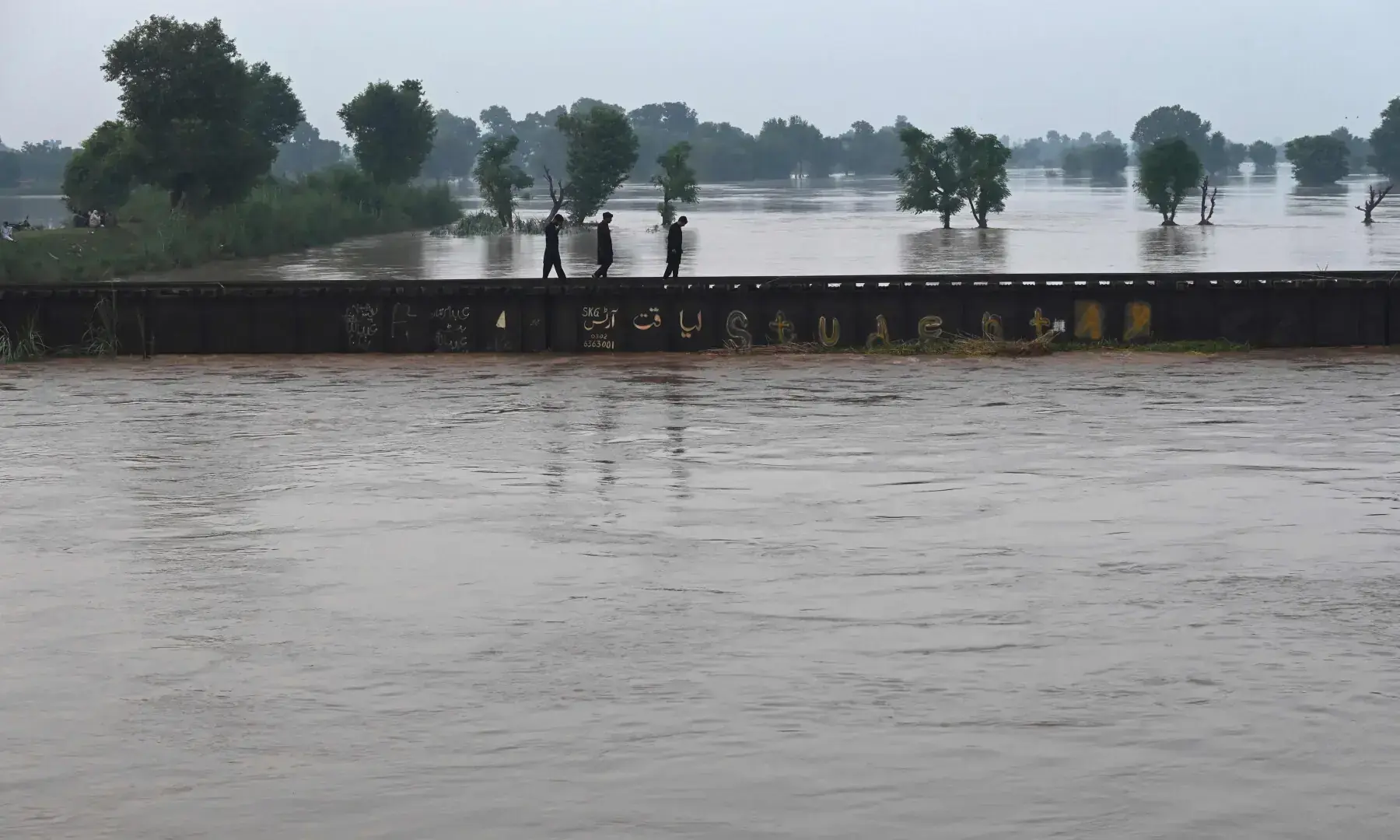 Commuters wade past the water in the flooded area of Narowal, a town of Punjab, on August 27, 2025. — AFP/File Commuters wade past the water in the flooded area of Narowal, a town of Punjab, on August 27, 2025. — AFP/File