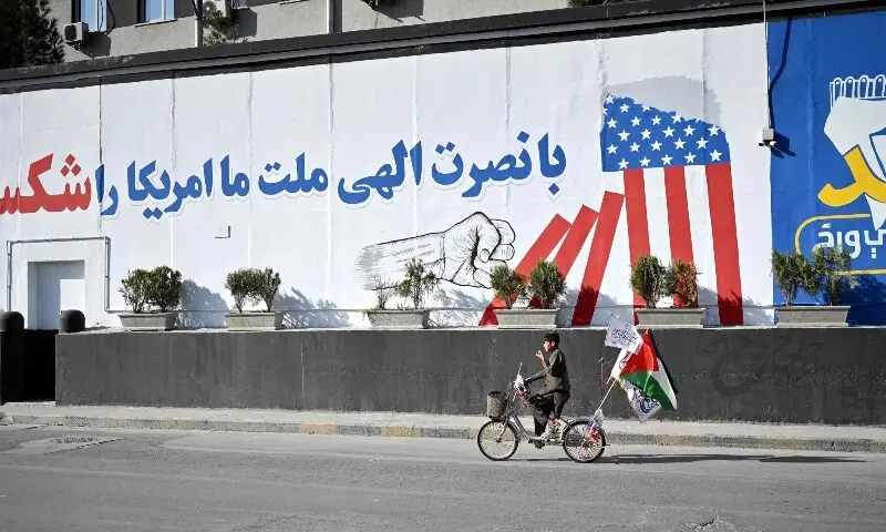 An Afghan cyclist rides past a wall mural reading “With divine help, our nation defeated America” in Kabul on August 15, 2026 as the Taliban government celebrates the fifth anniversary of their return to power. — AFP An Afghan cyclist rides past a wall mural reading “With divine help, our nation defeated America” in Kabul on August 15, 2026 as the Taliban government celebrates the fifth anniversary of their return to power. — AFP
