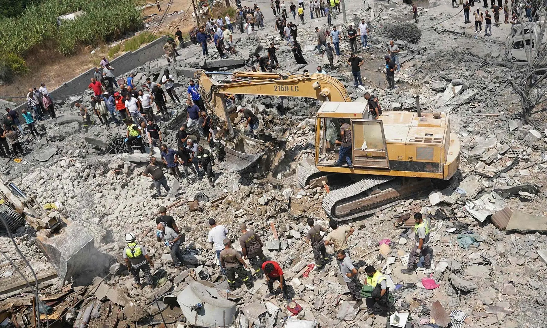 Heavy machinery, first aid responders and residents search the site of an Israeli airstrike that targeted a neighbourhood in the southern Lebanese village of Deir al-Zahrani on August 15, 2026. &mdash; AFP