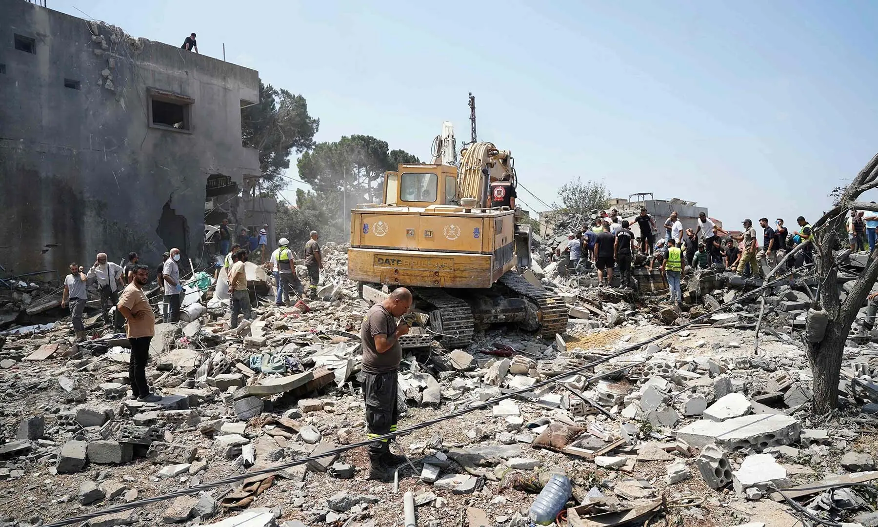 Heavy machinery, first aid responders and residents search the site of an Israeli airstrike that targeted a neighbourhood in the southern Lebanese village of Deir al-Zahrani on August 15, 2026. &mdash; AFP