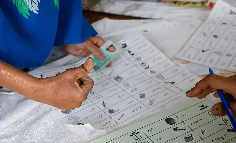 A voter with an ink mark on the thumb goes through paperwork to cast a vote during the general election in Karachi, on Feb 8, 2024— Reuters/File A voter with an ink mark on the thumb goes through paperwork to cast a vote during the general election in Karachi, on Feb 8, 2024— Reuters/File