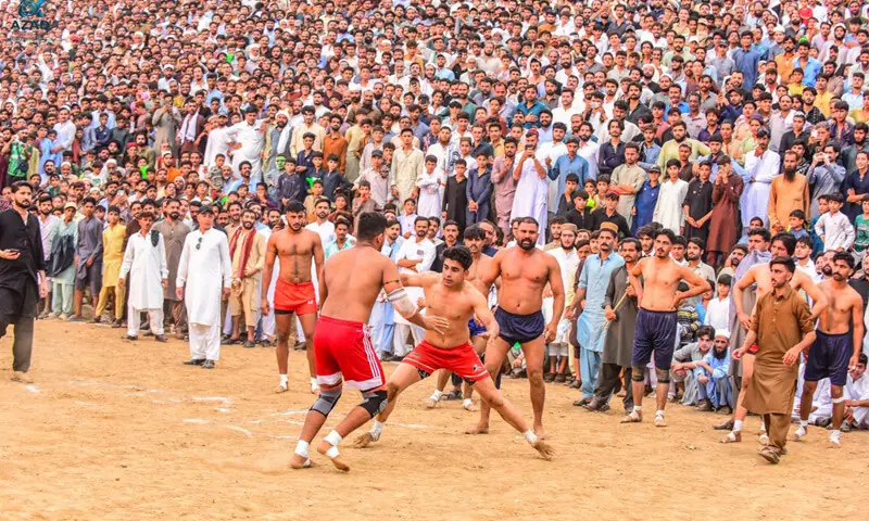 A player attempts to grab his rival during a kabaddi match at the New Balakot City Ground, Mansehra. &mdash; Dawn