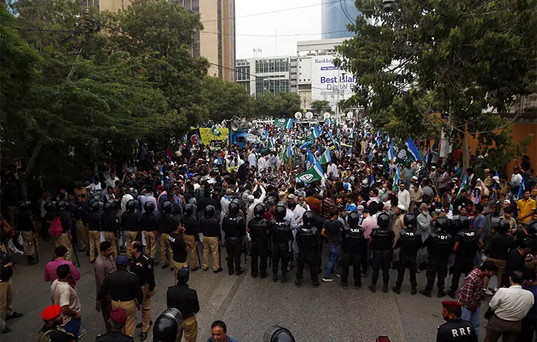 Policemen form a riot line to stop JI protesters from marching on Governor House. —Shakil Adil / White Star Policemen form a riot line to stop JI protesters from marching on Governor House. —Shakil Adil / White Star