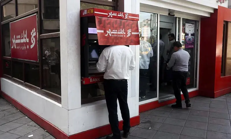 A man uses an ATM in front of a bank in Tehran, Iran on August 17, 2026. — Reuters