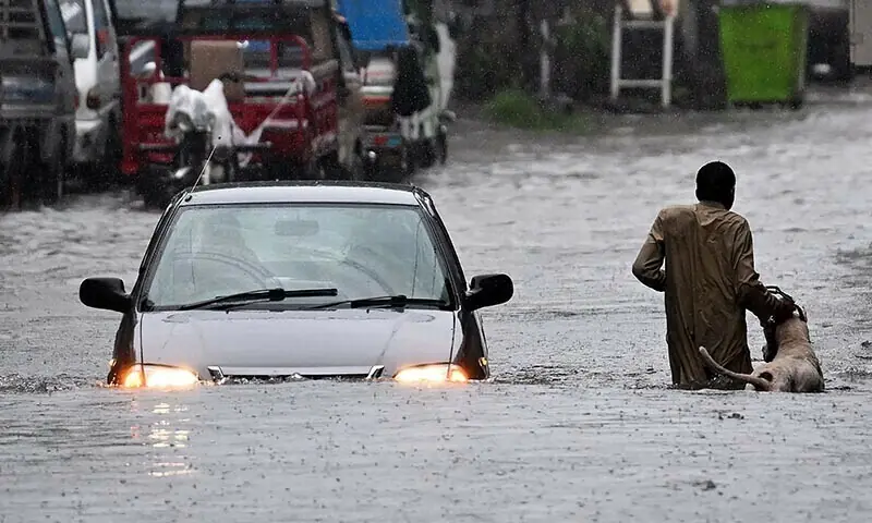 A man along with his dog while a car wade through a flooded street during heavy monsoon rains in Rawalpindi on July 17, 2025. — AFP/File A man along with his dog while a car wade through a flooded street during heavy monsoon rains in Rawalpindi on July 17, 2025. — AFP/File
