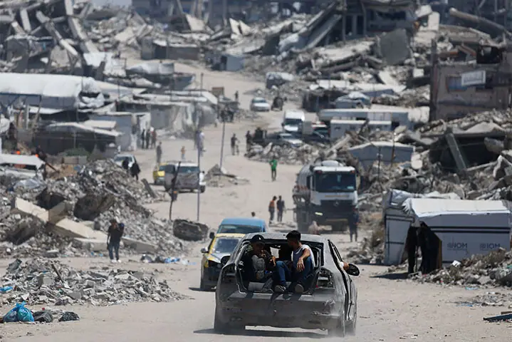 Beit Lahiya: People ride on a car at a site destroyed during an Israeli offensive in northern Gaza Strip.&mdash;Reuters