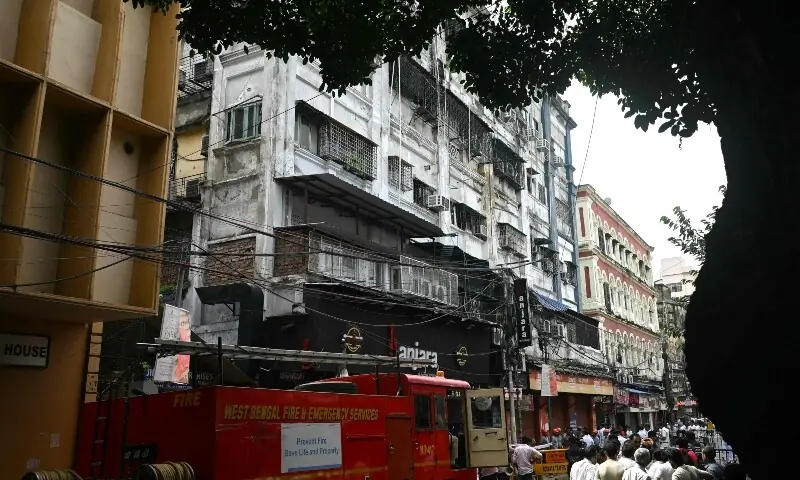 Onlookers and fire personnel gather at the site following a fire at a hotel in Kolkata on August 19, 2026. — AFP