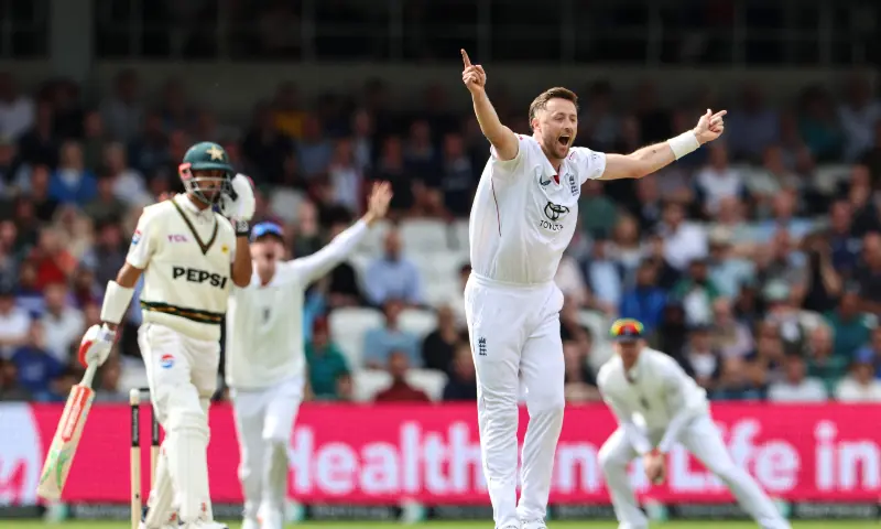 England's Ollie Robinson (R) celebrates after the dismissal of Pakistan's batter Shan Masood on the opening day of the first test match between England and Pakistan at Headingley cricket ground in Leeds, northern England on August 19, 2026. &mdash; AFP