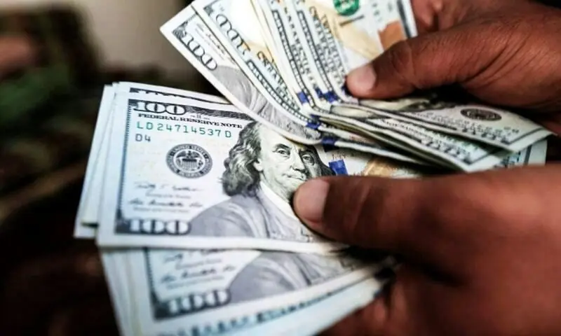 A file photo of a person holding US dollar bills. &mdash; AFP/File