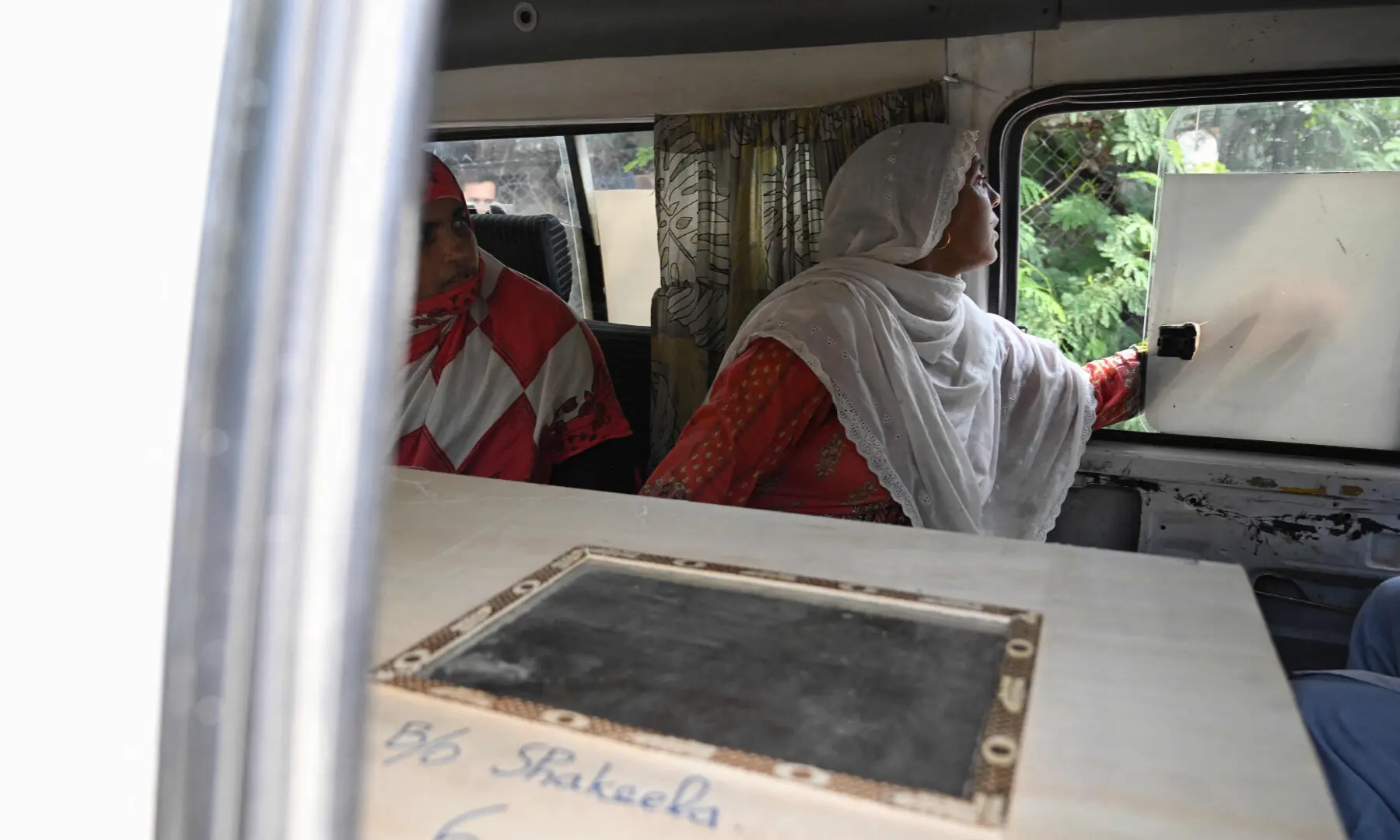 Mourners sit beside a child's coffin while being transported in an ambulance following a fire outside the Mother and Child Health (MCH) ward at the Pakistan Institute of Medical Sciences (Pims) hospital in Islamabad on Aug 26, 2026. &mdash; AFP