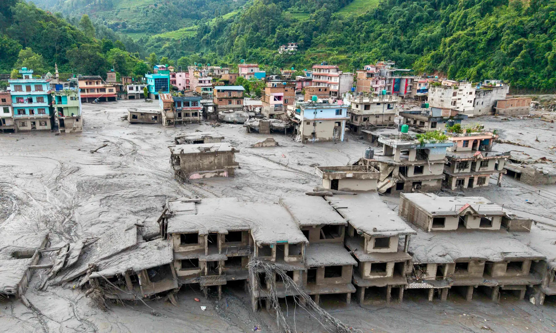 An aerial view shows houses lying deluged in sludge after flash floods at Devighat, Bidur Municipality in Nepal's Nuwakot district on Aug 27, 2026. &mdash; AFP