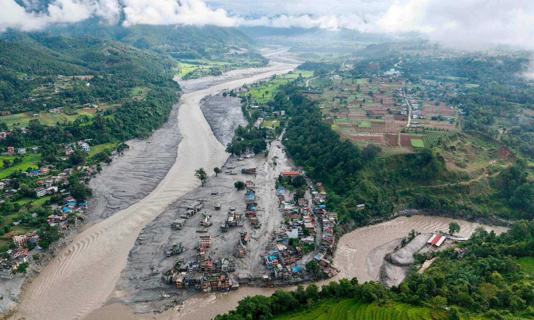 An aerial view shows houses lying deluged in sludge after flash floods at Devighat, Bidur Municipality, along the confluence of the Trishuli and Tadi rivers in Nepal's Nuwakot district on Aug 27, 2026. &mdash; AFP