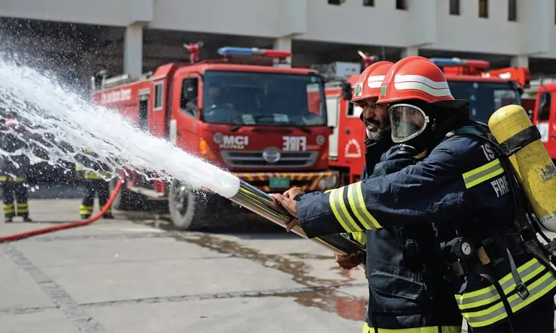 This file photo, used for representational purposes, shows two firefighters checking the hose of a fire tender in Islamabad. — Reuters This file photo, used for representational purposes, shows two firefighters checking the hose of a fire tender in Islamabad. — Reuters