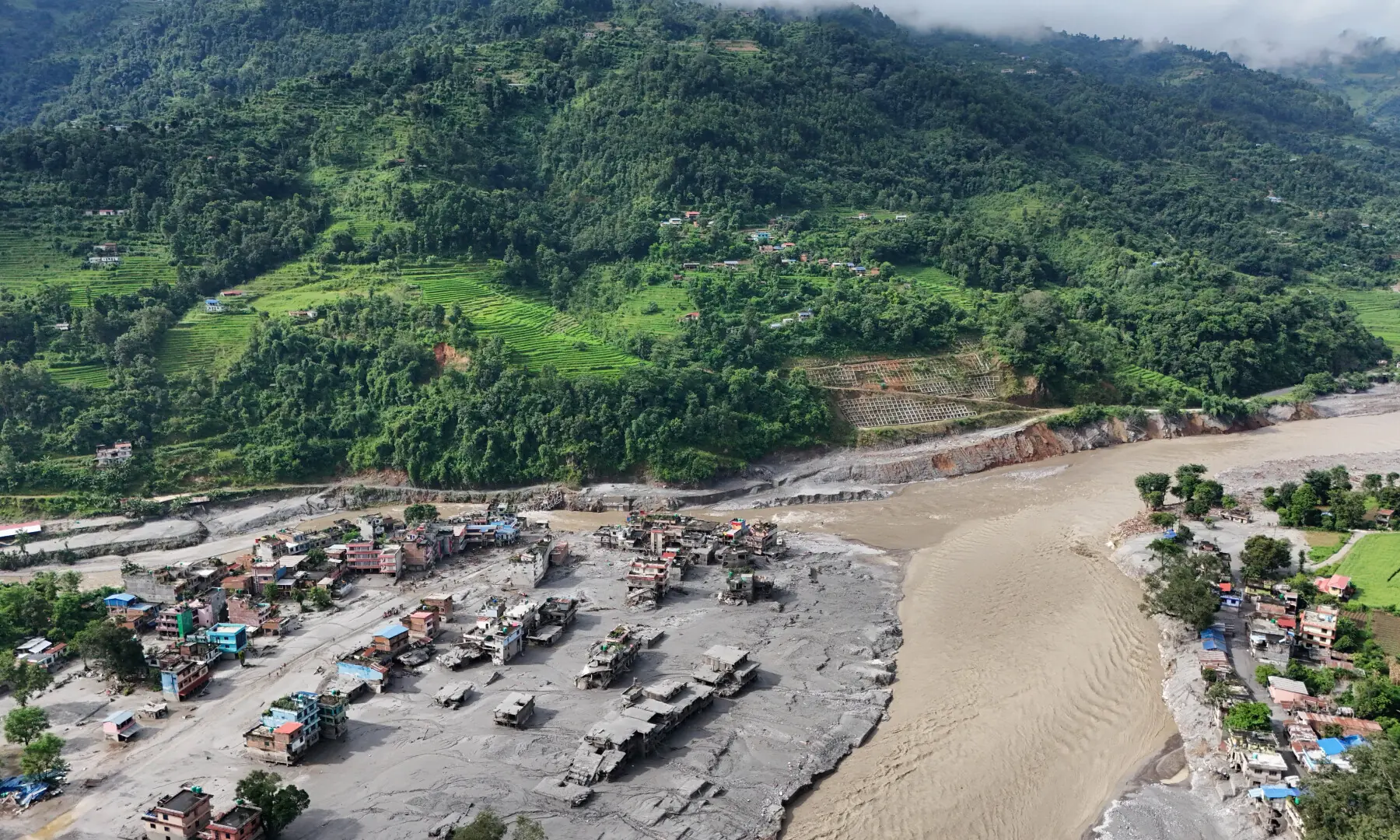 A drone view shows mud covering buildings and property following devastating floods at Trishuli in Nuwakot district, Nepal, on Aug 27, 2026. &mdash; Reuters