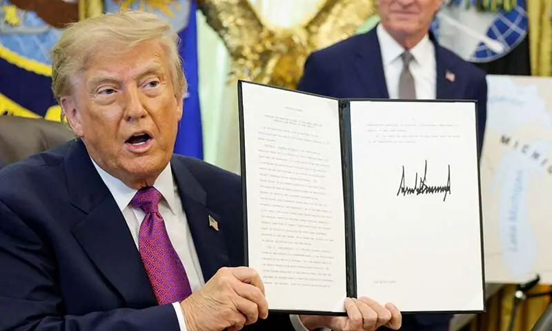 US President Donald Trump holds up an executive order renaming Lake Ontario as Lake America after signing it at the Oval Office of the White House in Washington, DC, the US on August 27, 2026. &mdash; Reuters