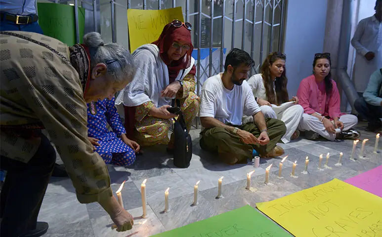 Civil society activists hold candle-light vigil for the victims of Pims tragedy outside the children OPD of the hospital in Islamabad on Thursday. &mdash; Photo by Mohammad Asim