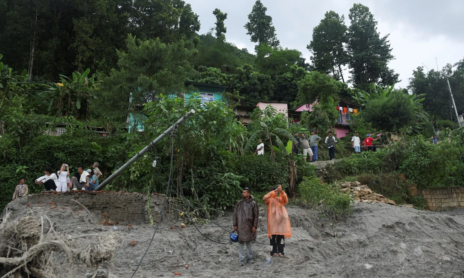 People stand on the remains of a house after flash floods and a mudslide at Trishuli Bazaar, Nuwakot, Nepal, on August 28, 2026. &mdash; Reuters