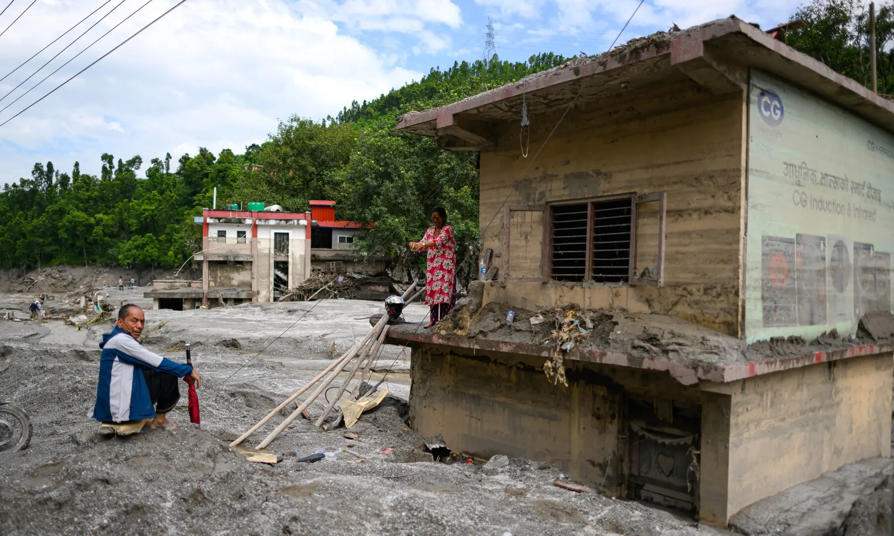 A woman (R) stands atop her house covered in mud in the aftermath of flash floods at Baireni in Nepal's Dhading district on Aug 30, 2026. — AFP A woman (R) stands atop her house covered in mud in the aftermath of flash floods at Baireni in Nepal's Dhading district on Aug 30, 2026. — AFP