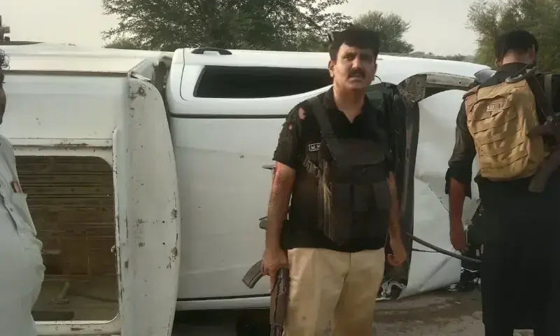 Police personnel stand beside the vehicle that overturned during an exchange of fire with terrorists in the Hathala area of Dera Ismail Khan . &mdash; Photo by Muhammad Irfan Mughal/File