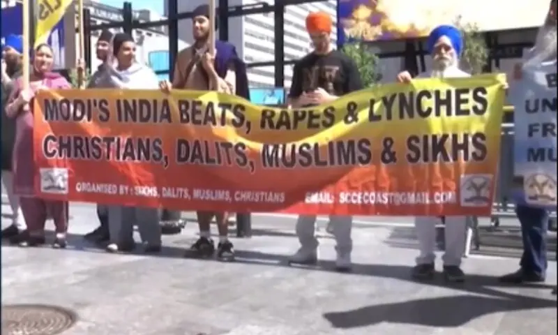 Protesters hold a banner during Rashtriya Swayamsevak Sangh chief Mohan Bhagwat's visit to New York. &mdash; screengrab via