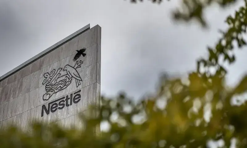 This photograph shows a crow flying next to the logo of Swiss food giant Nestle on the facade of its headquarters ahead of the company&rsquo;s third-quarter results announcement, in Vevey, western Switzerland on October 14, 2025. &mdash;AFP/File