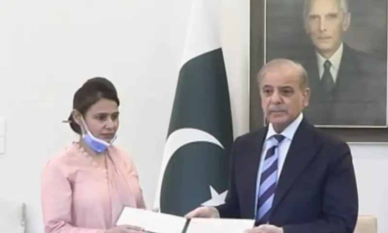 Prime Minister Shehbaz Sharif stands with Razia Noreen, a nurse who saved a child from the deadly fire at Pims hospital that killed 14 babies on Aug 26, at the PM House in Islamabad on Sep 3. &mdash; screengrab via Geo News TV