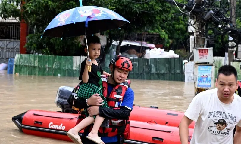 A rescue worker holds a child while evacuating residents by boat amid flooding caused by heavy rainfall from Typhoon Saudel in Minhou county, Fuzhou, Fujian province, China on September 3, 2026. &mdash; Reuters