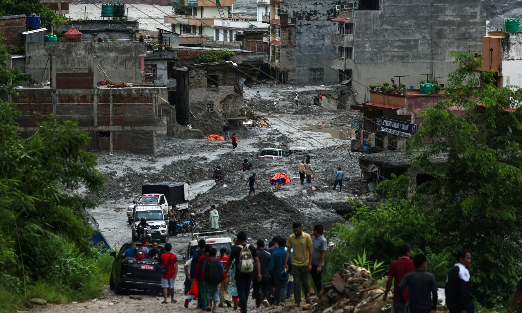 People travel past damaged buildings following the deadly flash floods and mudslides in Nuwakot district, Nepal on Sept 3, 2026. —Reuters