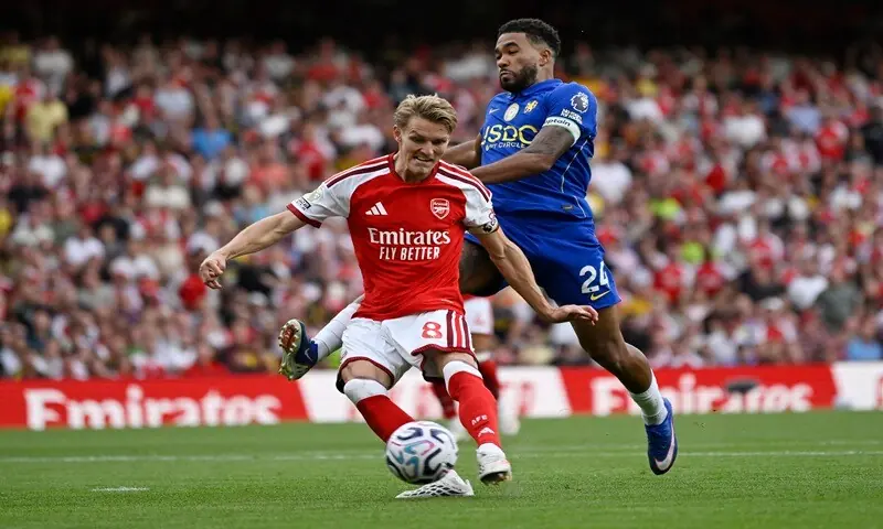 Arsenal's Martin Odegaard (L) shoots to score against Chelsea during their Premier League match at the Emirates Stadium in London on September 6, 2026. &mdash;Reuters