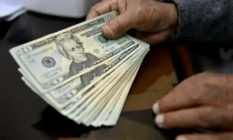 A file photo of a hand holding US dollars. &mdash; White Star/File