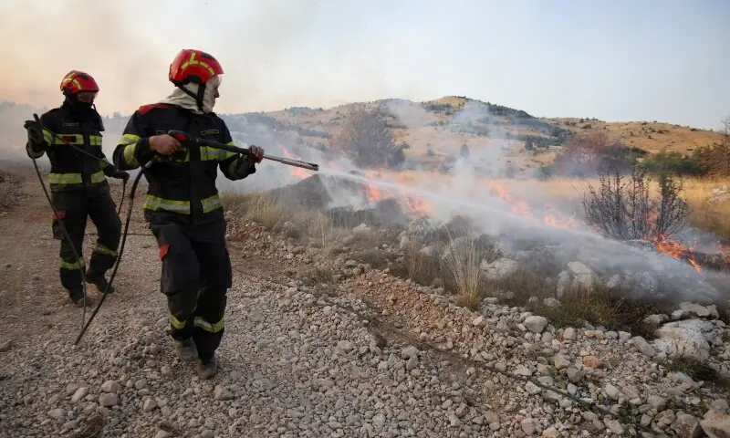 Firefighters use a hose to battle a forest fire in Trebisevo, Bosnia and Herzegovina, on September 7, 2026. &mdash; Reuters