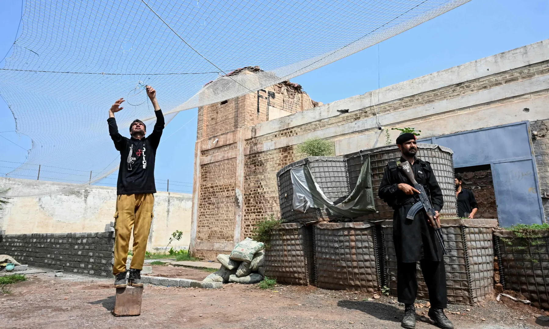 This photograph taken on Aug 4, 2026 shows security personnel fortifying a police post with Ukraine-style mesh barriers, at Bara in Khyber Pakhtunkhwa. &mdash; AFP
