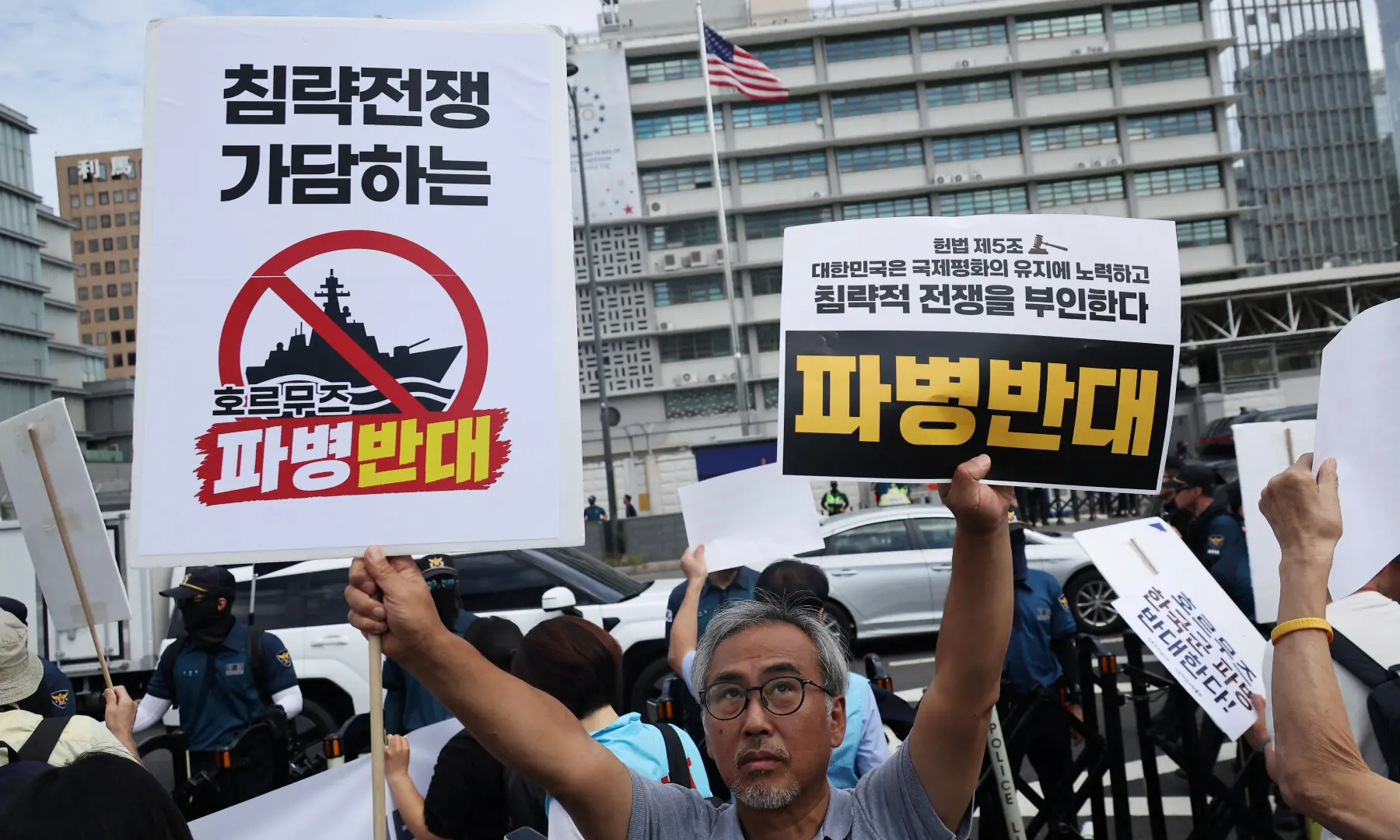 An activist holds up signs while marching on a street towards the Presidential Blue House during a protest against South Korea&rsquo;s possible military participation in the Strait of Hormuz, near the US Embassy in Seoul, South Korea on Sept 9, 2026. &mdash; Reuters