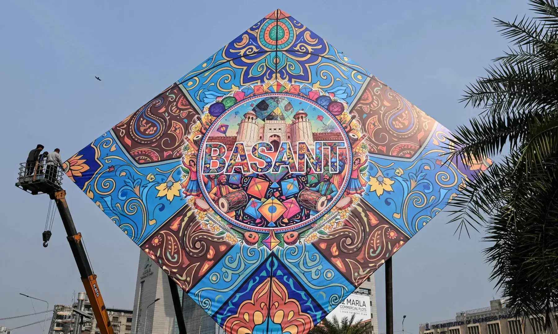 Workers install a large model of a kite celebrating the Basant festival in Lahore on Feb 3, 2026. &mdash; AFP/File