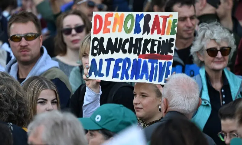 Protesters hold a sign reading 'Democracy does not need an alternative' referring to Germany's far-right Alternative for Germany (AfD) party, during a demonstration against the far-right in Berlin, Germany on September 12, 2026. — AFP Protesters hold a sign reading 'Democracy does not need an alternative' referring to Germany's far-right Alternative for Germany (AfD) party, during a demonstration against the far-right in Berlin, Germany on September 12, 2026. — AFP