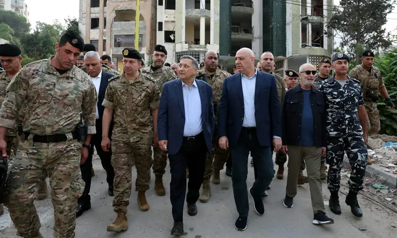 Lebanese president (centre-right) walks alongside security officials during a visit to Nabatieh.&mdash;AFP