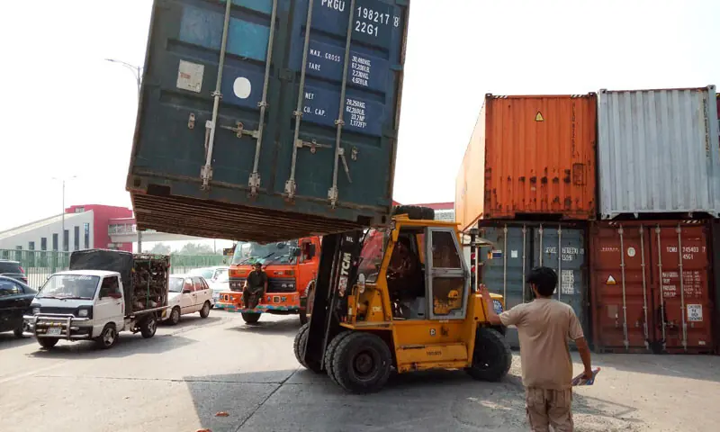 Authorities use a forklift to place containers on a road in the federal capital as part of security preparations and route-sealing measures ahead of the PTI rally scheduled for Sept 27.&mdash;INP