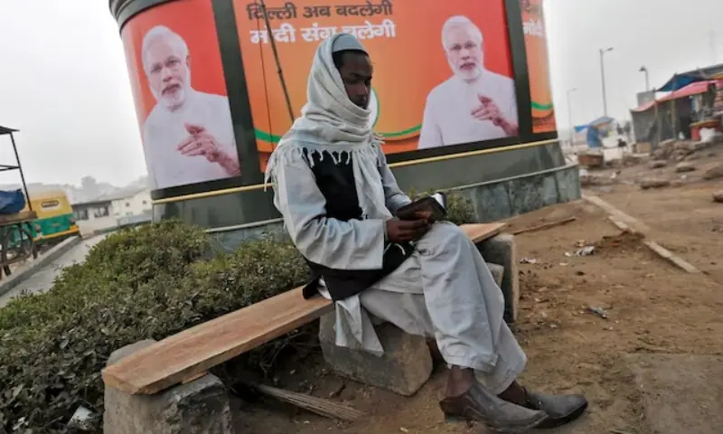 A Muslim man reads the Holy Quran as he sits in front of a billboard featuring India's Prime Minister Narendra Modi in New Delhi January 20, 2015. — Reuters A Muslim man reads the Holy Quran as he sits in front of a billboard featuring India's Prime Minister Narendra Modi in New Delhi January 20, 2015. — Reuters