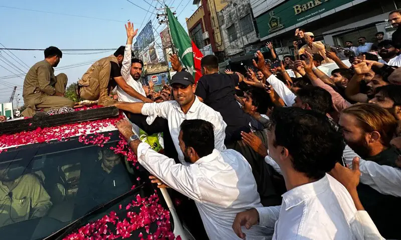 KP CM Sohail Afridi waves to the PTI workers while his entourage passes through the Gujrat’s Circular Road on Wednesday.—Dawn KP CM Sohail Afridi waves to the PTI workers while his entourage passes through the Gujrat’s Circular Road on Wednesday.—Dawn
