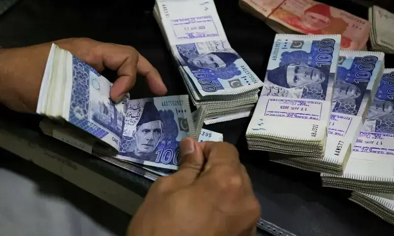 In this file photo, an employee counts Pakistani rupee notes at a bank in Peshawar on August 22, 2023. — Reuters/File In this file photo, an employee counts Pakistani rupee notes at a bank in Peshawar on August 22, 2023. — Reuters/File