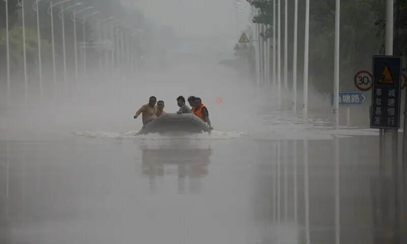 People ride a boat through a flooded road after the rains and floods brought by remnants of Typhoon Doksuri, in Zhuozhou, Hebei province, China August 3, 2023. &mdash; Reuters/File