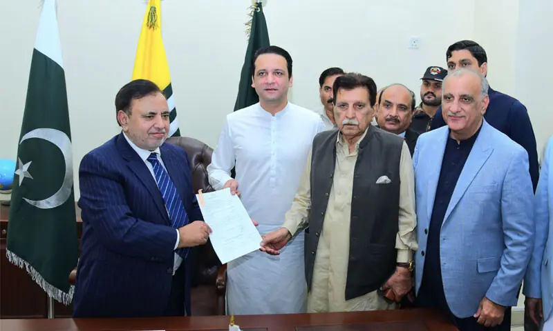 AJK PM Iftikhar Gillani (centre) and former premier Raja Farooq Haider submit the nomination papers of Dr Najeeb Naqi (right) as his seconder and proposer, respectively, to the chief election commissioner.—Photo by the writer AJK PM Iftikhar Gillani (centre) and former premier Raja Farooq Haider submit the nomination papers of Dr Najeeb Naqi (right) as his seconder and proposer, respectively, to the chief election commissioner.—Photo by the writer