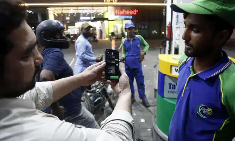 A man shows a pump attendant his registration for the fuel subsidy scheme in Karachi.—Shakil Adil/ File A man shows a pump attendant his registration for the fuel subsidy scheme in Karachi.—Shakil Adil/ File