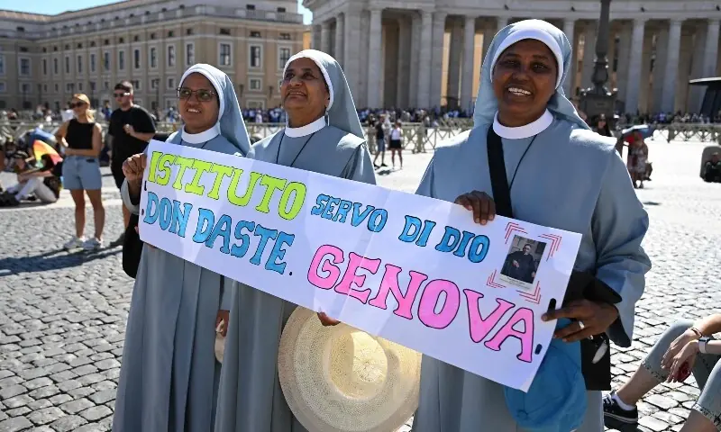 Nuns hold a banner reading the name of their insitute before, as they await Pope Leo XIV’s address from the window of the apostolic palace overlooking St Peter’s Square during his Sunday Angelus prayer at the Vatican on September 20. — AFP