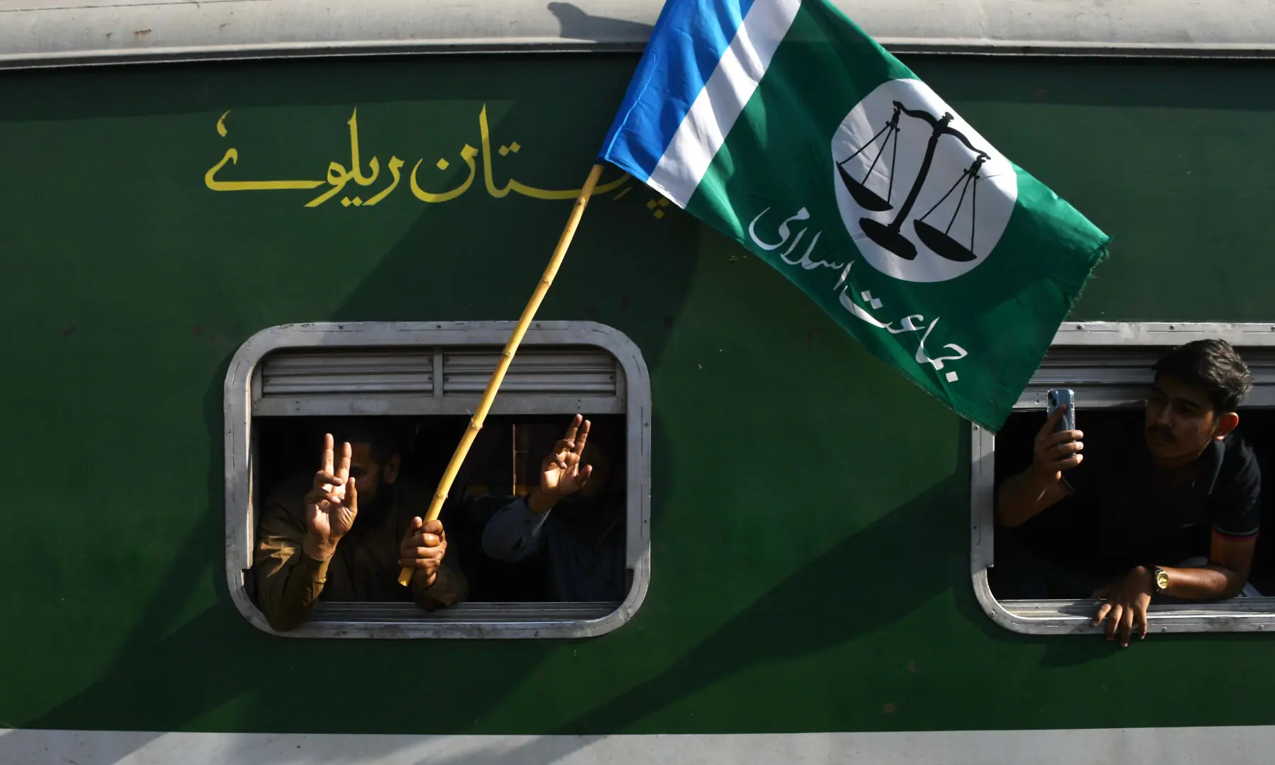 Jamaat-i-Islami supporters in a train wave the party flag at Hyderabad Railway Station on Sept 20, 2026. &mdash; Umair Ali