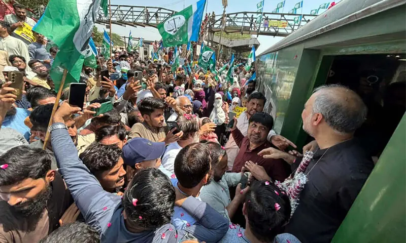 Jamaat-i-Islami chief Hafiz Naeem greets supporters as his party&rsquo;s train march to the capital sets off from Karachi Cantt Station.&mdash;PPI