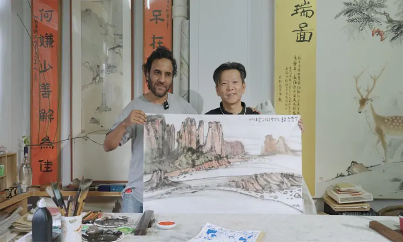 Algerian artist Yasser Ameur and Chinese painter Zhang Qiuju pose together with the ink painting of the desert that Zhang gifted to Yasser.—Courtesy China Daily Algerian artist Yasser Ameur and Chinese painter Zhang Qiuju pose together with the ink painting of the desert that Zhang gifted to Yasser.—Courtesy China Daily