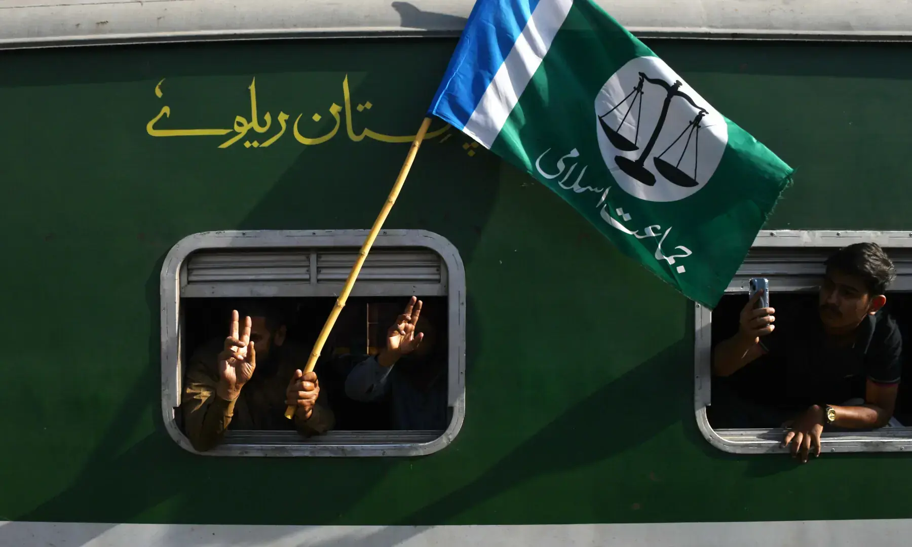 Jamaat-i-Islami supporters in a train wave the party flag at Hyderabad Railway Station on Sept 20, 2026. &mdash; Umair Ali