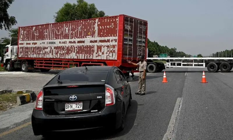 A police officer diverts traffic on the Islamabad&ndash;Peshawar Motorway blocked with trucks placed by authorities in Islamabad on September 24, 2026. --Reuters/File