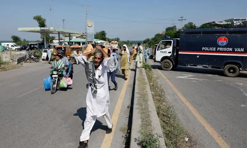 AN elderly man carries belongings on his shoulder as he walks to his village after police closed the Grand Trunk Road, in anticipation of PTI&rsquo;s protest march to Islamabad.&mdash;Reuters